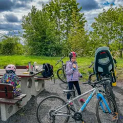 Dzieci w kaskach przy rowerach, przerwa na piknik. Czas na rower!
