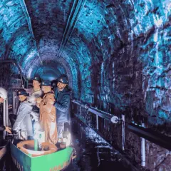 Podziemna łódź w kopalni, jedna z gliwickich atrakcji, zabiera turystów w podróż przez oświetlony na niebiesko tunel.