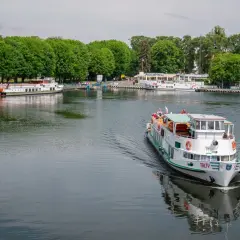 Rejs po jeziorze w Giżycku to jedna z głównych atrakcji. Statek "Tałty" płynie w stronę portu, gdzie cumują inne jednostki.