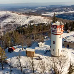 Wieża widokowa na Biskupiej Kopie w zimowej scenerii. Śnieg pokrywa okoliczne wzgórza i lasy.