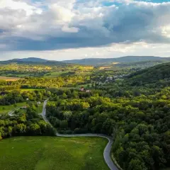 Malowniczy krajobraz z krętą drogą wśród zielonych wzgórz i lasów. Idealne miejsce na letnie wycieczki i odkrywanie atrakcji Wisły.