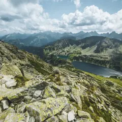 Widok z Kozi Wierch na Tatry. Skaliste zbocza, zielone doliny i dwa jeziora.