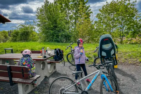 Dzieci w kaskach przy rowerach, przerwa na piknik. Czas na rower!
