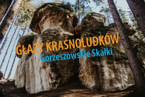 Imponujące głazy krasnoludków w Gorzeszowskich Skałkach, otoczone wysokimi drzewami.