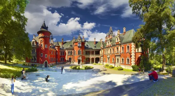 Zamek w Mosznej, jedna z najpiękniejszych śląskie atrakcje, z parą młodą i fotografami na dziedzińcu.