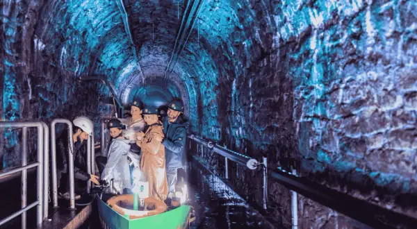 Podziemna łódź w kopalni, jedna z gliwickich atrakcji, zabiera turystów w podróż przez oświetlony na niebiesko tunel.