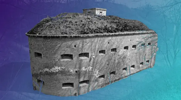 Okazała góra gradowa, ceglany fort z licznymi otworami, otoczony zimowym lasem.