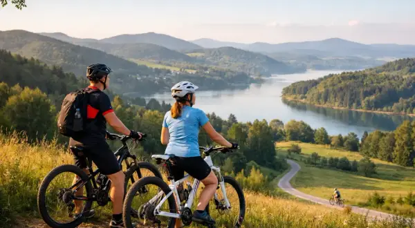 Para rowerzystów podziwia malownicze krajobrazy Podkarpacia, odkrywając urokliwe trasy rowerowe nad jeziorem.