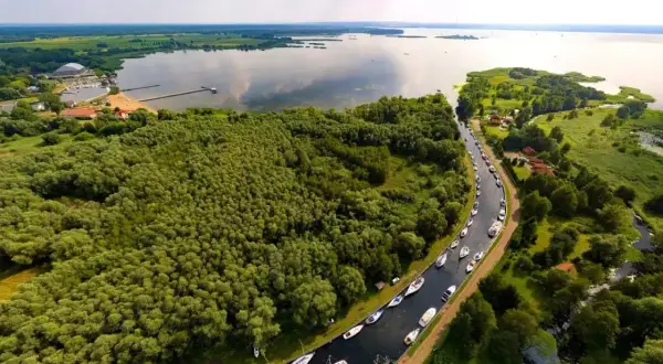 Malowniczy widok na Zalew Szczeciński z rzędem łodzi przycumowanych wzdłuż kanału.