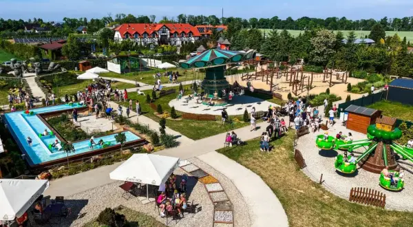 Wesołe miasteczko pełne atrakcji dla dzieci pomorskie: karuzela, zjeżdżalnie, wodny plac zabaw i mnóstwo uśmiechniętych rodzin.