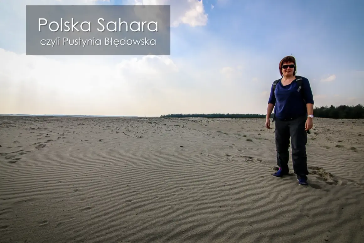 Kobieta stoi na piaszczystym terenie, który przypomina pustynię. To polska Sahara, czyli Pustynia Błędowska.