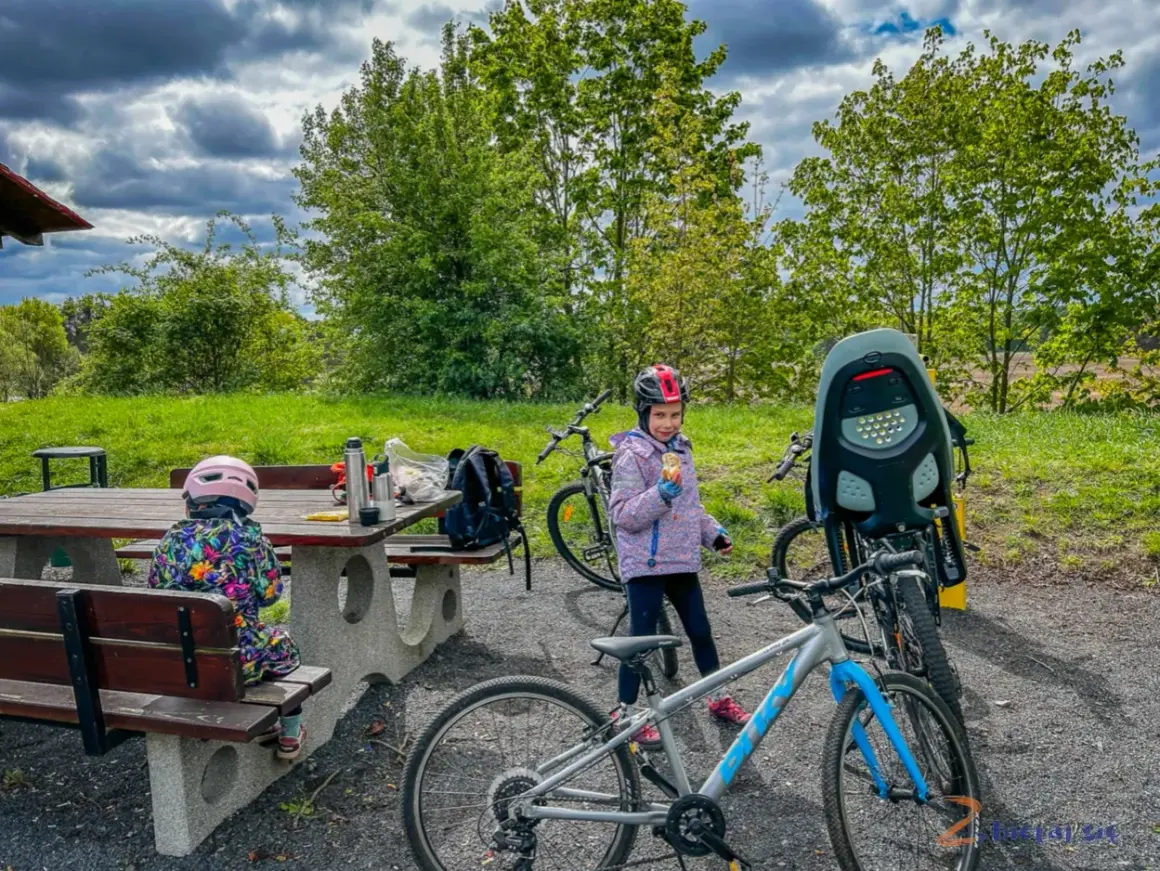 Dzieci w kaskach przy rowerach, przerwa na piknik. Czas na rower!