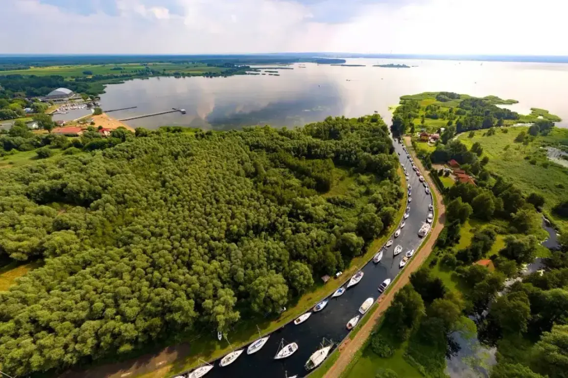 Malowniczy widok na Zalew Szczeciński z rzędem łodzi przycumowanych wzdłuż kanału.
