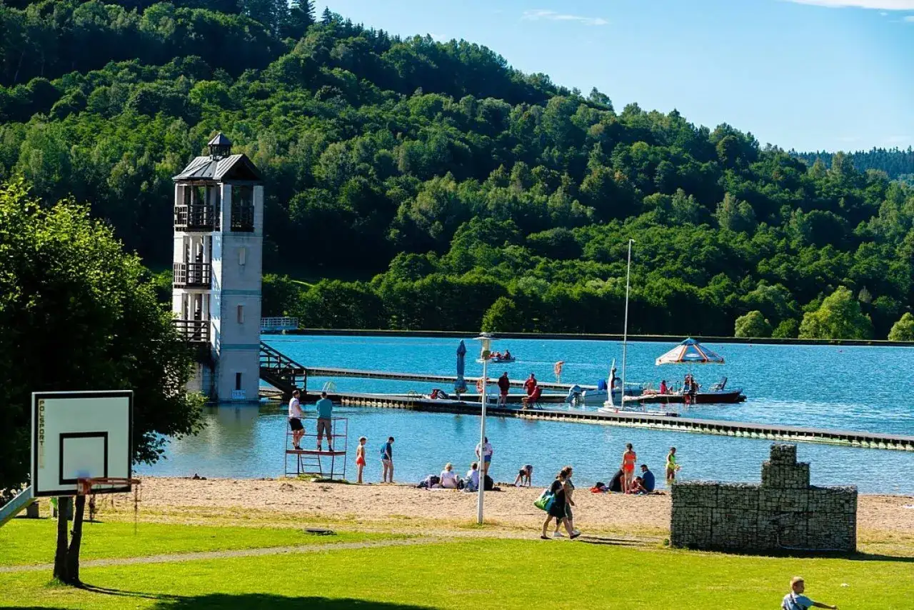 Słoneczny dzień nad zalewem Stara Morawa. Ludzie odpoczywają na plaży, pływają i korzystają z uroków lata.