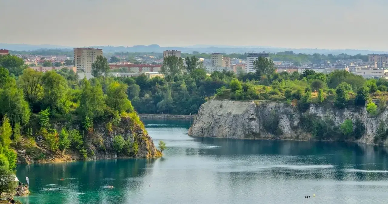 Skałki Twardowskiego w Krakowie, z turkusową wodą i zielonymi zboczami, na tle miejskiej panoramy.