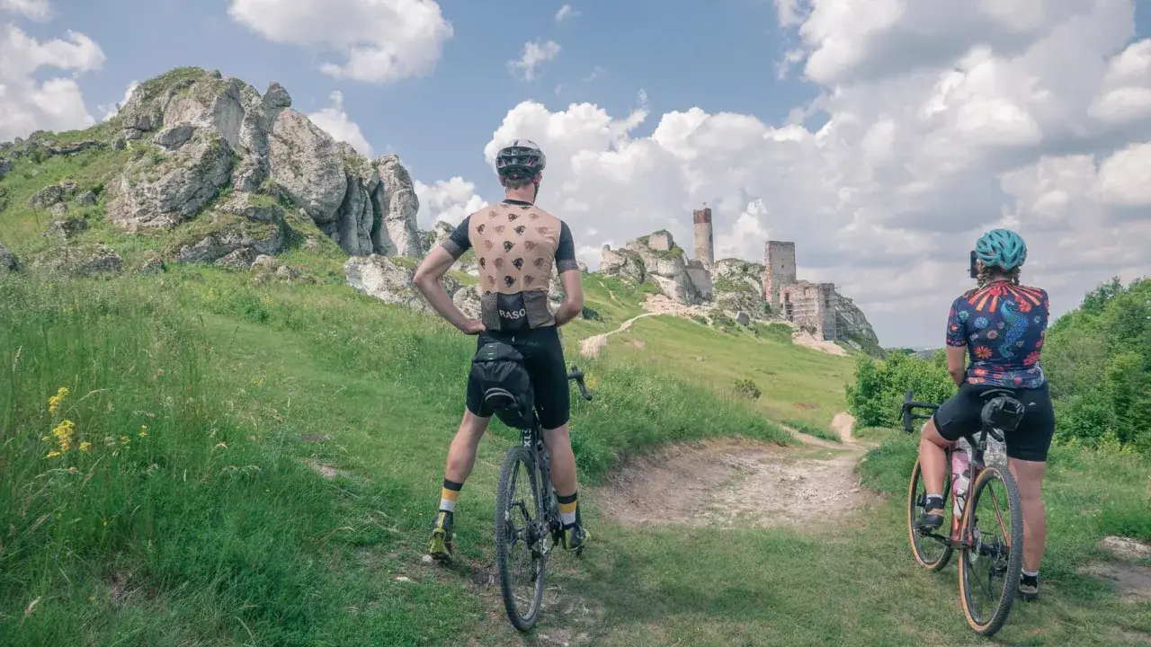Rowerzyści na tle ruin zamku na Szlaku Orlich Gniazd. Malowniczy krajobraz Jury Krakowsko-Częstochowskiej.