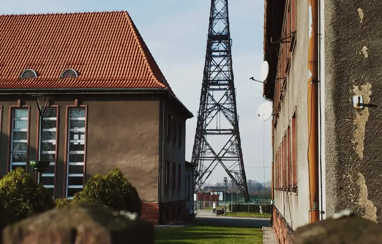 Wieża radiowa w Gliwicach, jedna z gł&oacute;wnych atrakcji miasta, g&oacute;ruje nad budynkami.