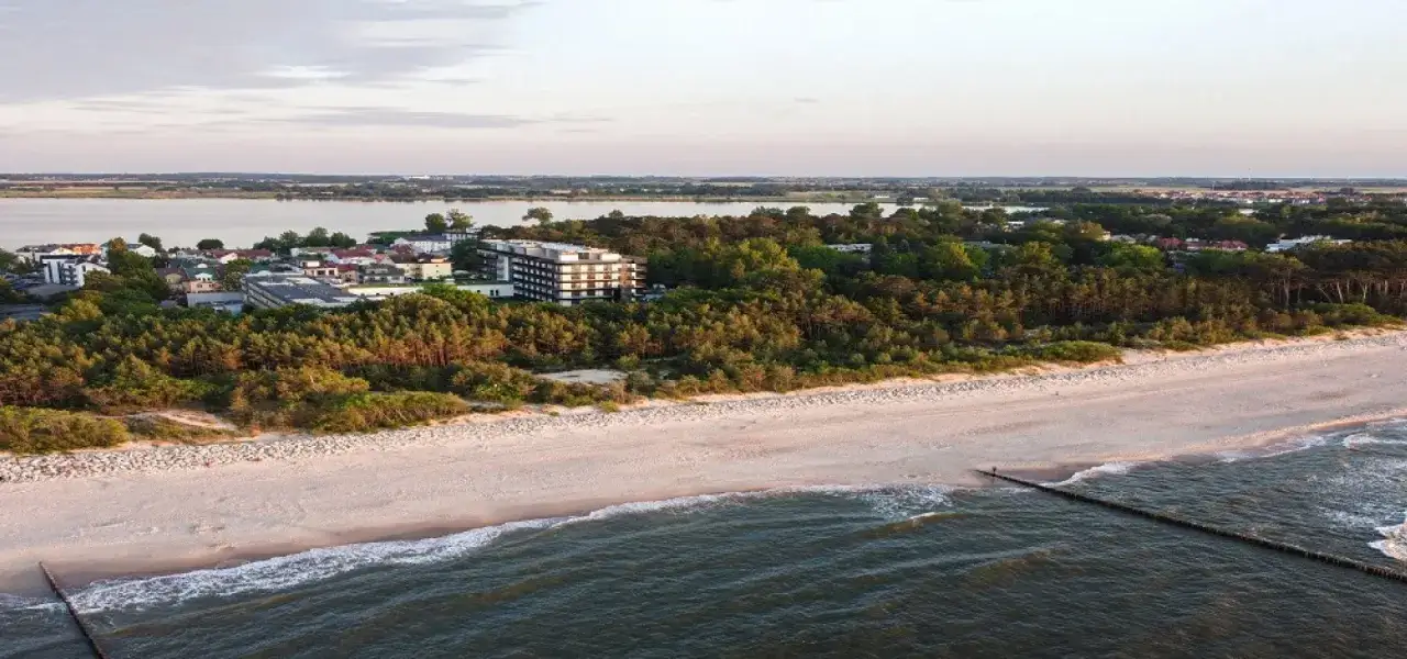 Widok na plażę, morze i zabudowania w Mielnie. W oddali jezioro i las. Idealne miejsce na wakacyjne atrakcje w Mielnie.