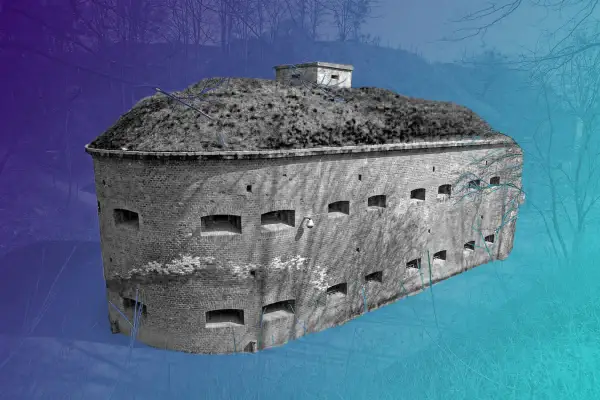 Okazała góra gradowa, ceglany fort z licznymi otworami, otoczony zimowym lasem.