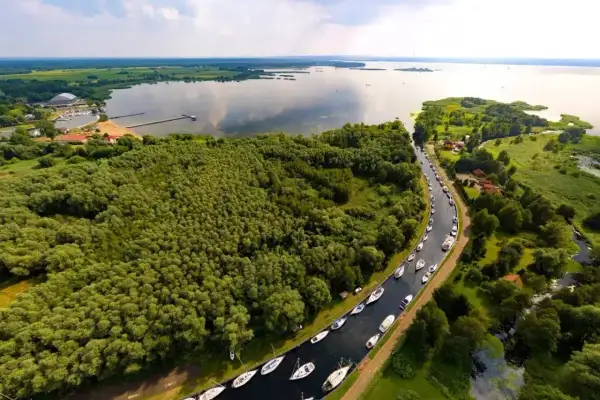 Malowniczy widok na Zalew Szczeciński z rzędem łodzi przycumowanych wzdłuż kanału.